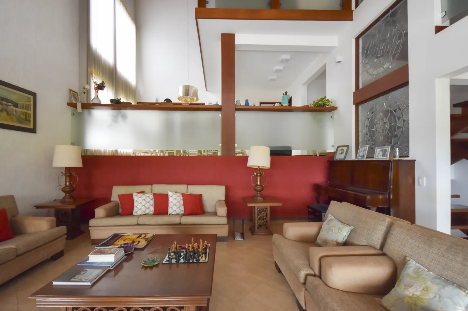 Segunda perspectiva da sala com aparador em madeira e acervo de arte