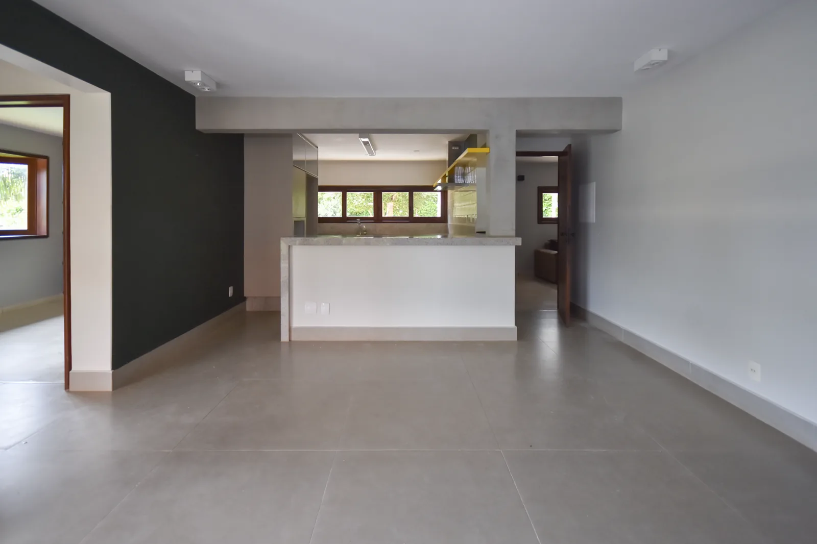 Sala de estar da casa de hóspedes com parede em bordô e sofá em veludo